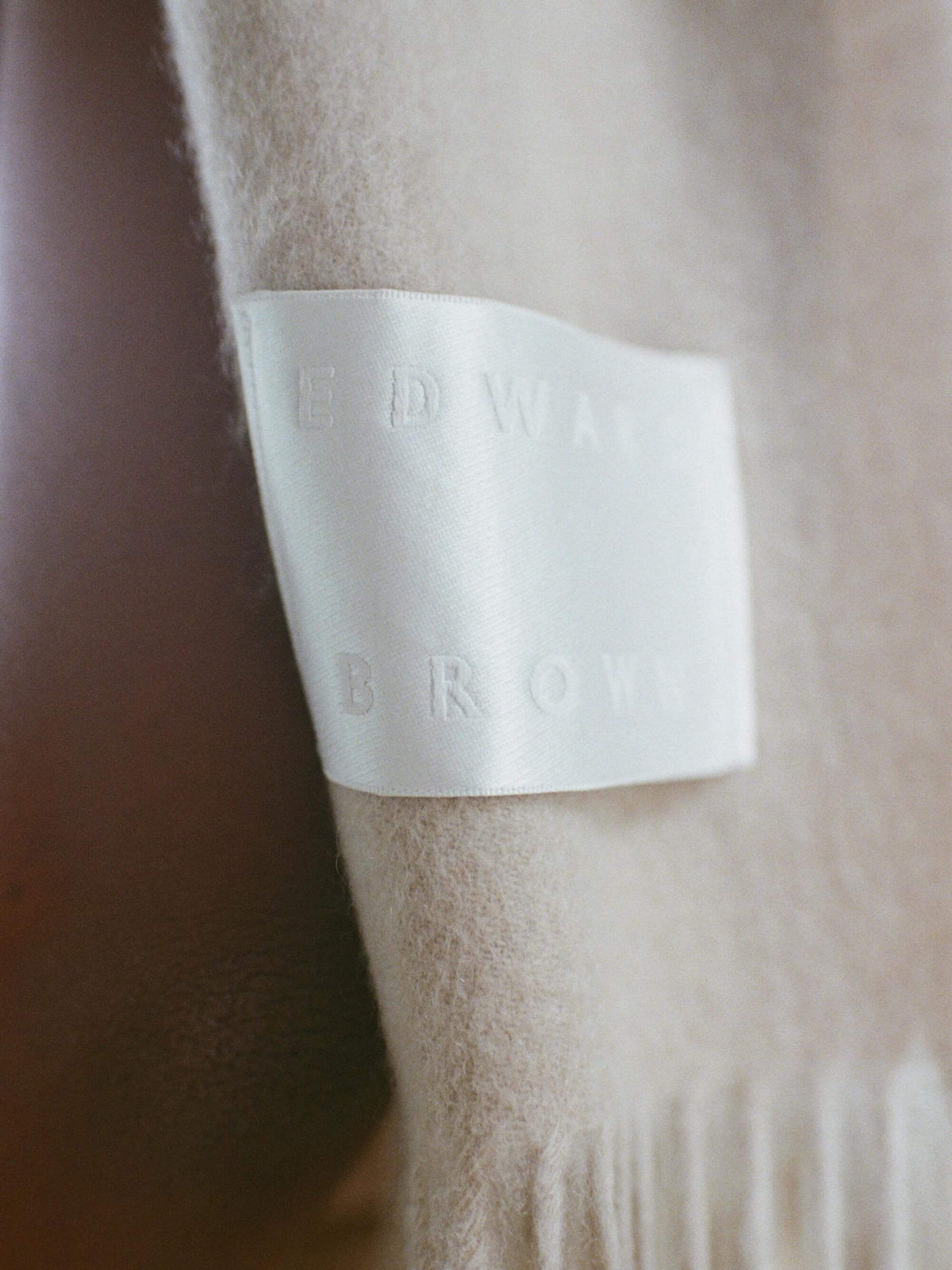 ベージュのカシミヤストールに付いたEDWARD BROWNのブランドラベル